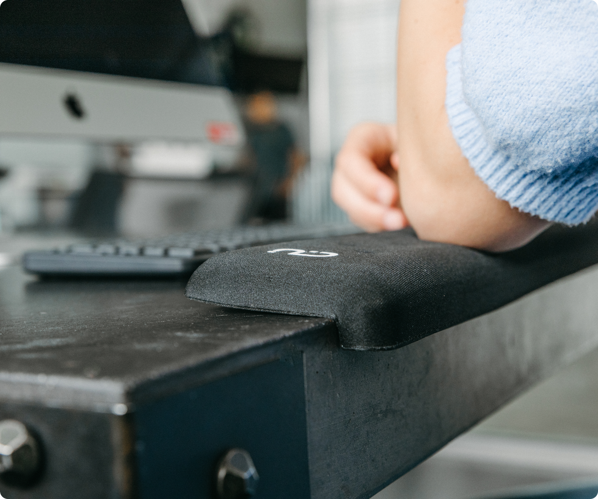 
                  
                    Person using a computer with a black wrist rest on a desk
                  
                