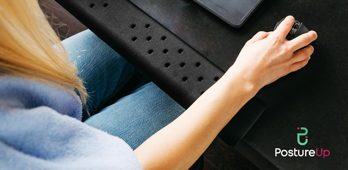 
                  
                    Person using a laptop with a black laptop stand, wearing blue jeans, on a dark surface.
                  
                